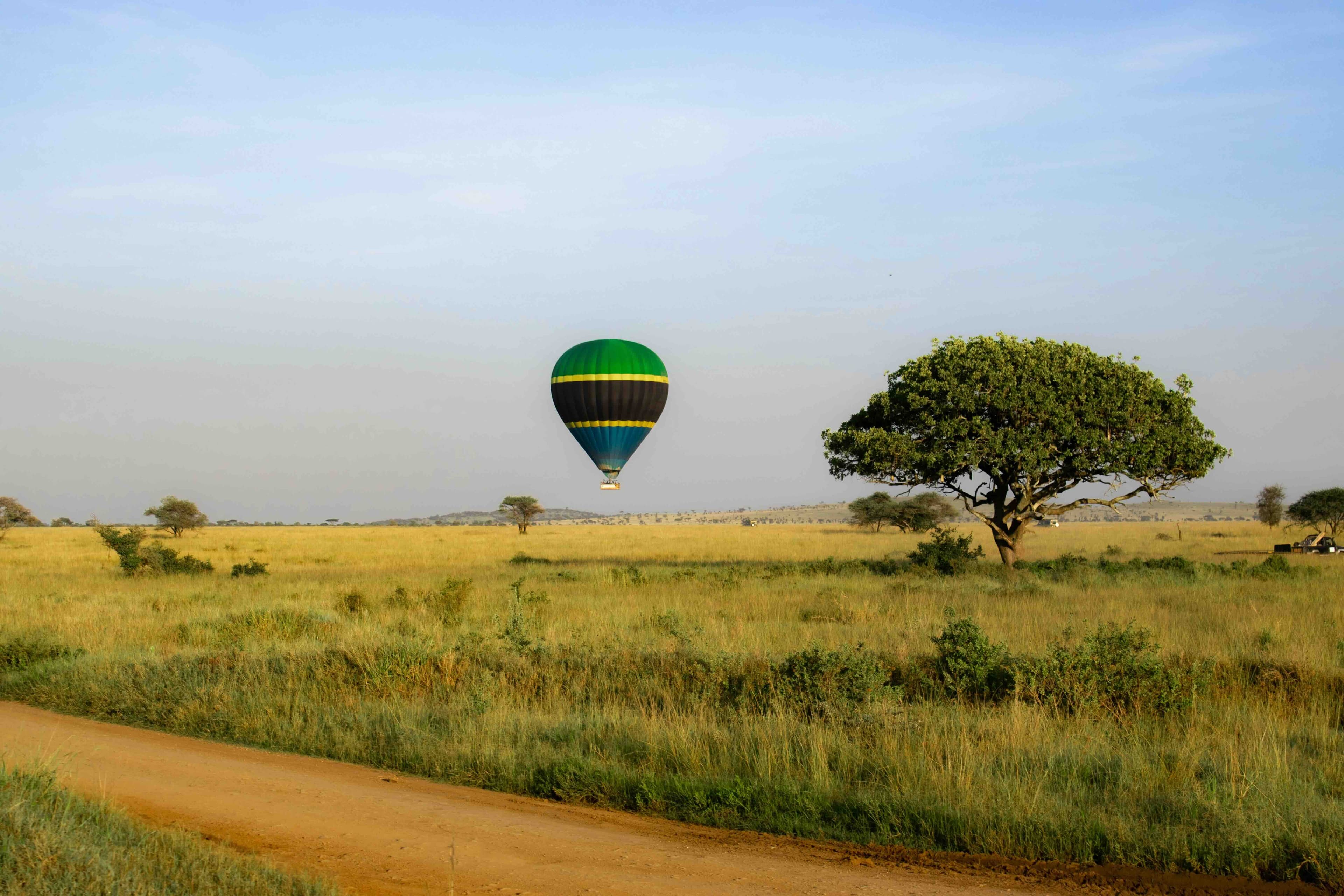 Montgolfière au-dessus des plaines du Serengeti au lever du jour et Plage de sable blanc et eau turquoise à Nungwi, Zanzibar