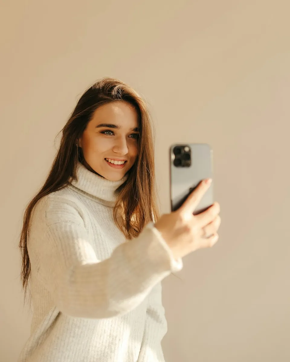 Une créatrice de contenu fait un selfie avec son téléphone